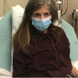 Woman patient wearing mask laying on hospital bed